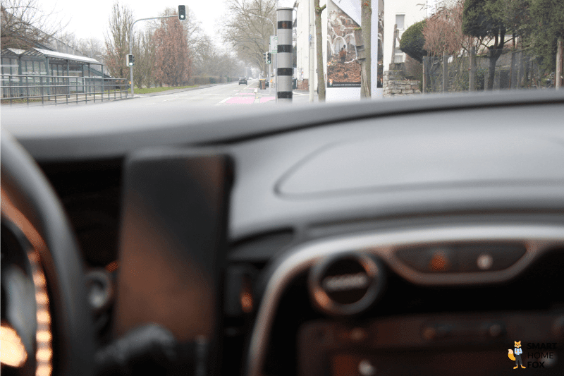 Der Ooono Co-Driver No1 Verkehrsalarm hängt im Auto und der Wagen steht vor einem festen Blitzer